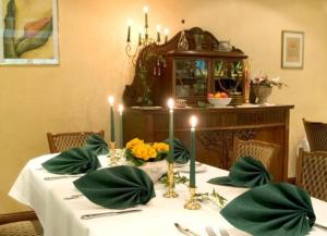 a table with a white table cloth and candles on it at Hotel Ferien auf der Heid in Eversen