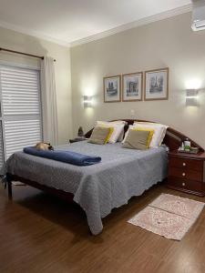 a bedroom with a bed with a dog laying on it at Chácara Jatobá in Espirito Santo Do Pinhal
