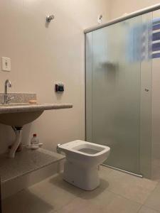 a bathroom with a shower and a toilet and a sink at Chácara Jatobá in Espirito Santo Do Pinhal
