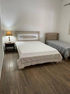 a bedroom with two beds and a table with a lamp at Chácara Jatobá in Espirito Santo Do Pinhal