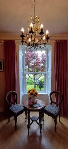 a dining room with a table and two chairs and a window at The Nest at Corbies Rest in Inverness
