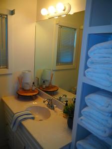 a bathroom with a sink and a mirror and towels at The Bright And Breezy - Lakefront With Spa! in Frankfort