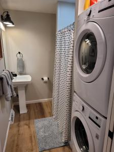 a laundry room with a washing machine and a sink at White Birch - Riverfront And Newly-remodeled! in Elberta +40 photos