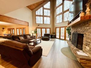 a living room with couches and a stone fireplace at Lake Dreaming in McHenry