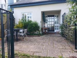a patio with a table and chairs in front of a house at Jasmine cottage-1 King bed room, 40 mins to Cotswolds 90 mins to Oxford and Bath in Great Malvern