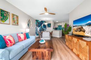 a living room with a blue couch and a table at Hip Hawaiian Oceanfront Vistas in Kihei