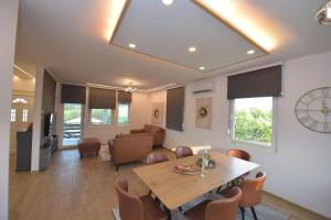a dining room and living room with a table and chairs at Village Relax House in Čerević