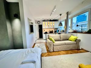 Una sala de estar con un sofá y una cocina. en SILVER AirCondition WiFi 1Gbs 85'TV Netflix, en Varsovia