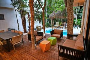 a wooden deck with chairs and tables and a pool at Luxury 5-br Oasis Golf, Private Pool, Beach! in Akumal