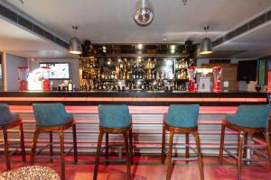 a bar with blue chairs in front of a bar at Best Western La Vista Pathankot in Pathānkot