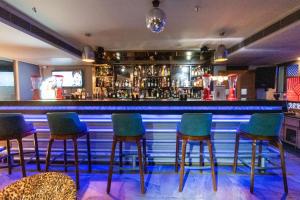 a bar with green chairs and a blue counter at Best Western La Vista Pathankot in Pathānkot