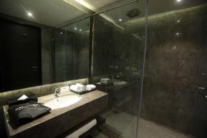 a bathroom with a sink and a glass shower at Best Western Plus Tejvivaan in Visakhapatnam +37 photos