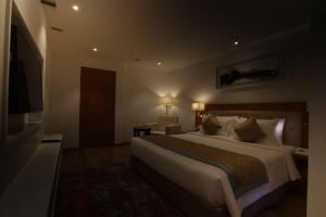 a hotel room with a large bed and a television at Best Western Plus Tejvivaan in Visakhapatnam