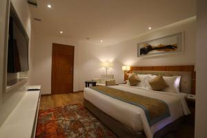 a hotel room with a large bed and a television at Best Western Plus Tejvivaan in Visakhapatnam