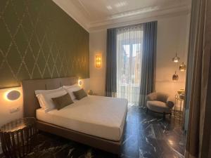 a bedroom with a bed and a chair and a window at Lovely Rooms in La Spezia