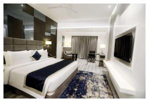 a hotel room with a large bed and a desk at Best Western Plus Tejvivaan in Visakhapatnam