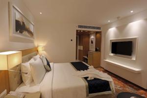 a hotel room with a bed and a television at Best Western Plus Tejvivaan in Visakhapatnam
