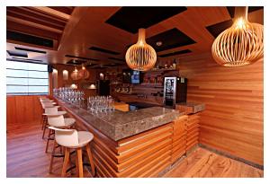 a bar with a row of bar stools and lights at Best Western Plus Tejvivaan in Visakhapatnam