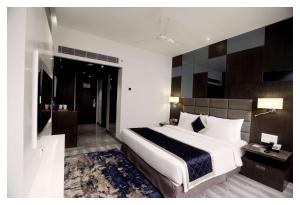 a bedroom with a large white bed and a bathroom at Best Western Plus Tejvivaan in Visakhapatnam