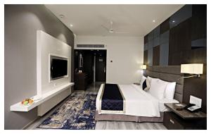 a hotel room with a bed and a television at Best Western Plus Tejvivaan in Visakhapatnam