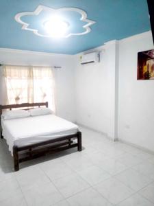 a bedroom with a bed and a blue ceiling at Hostal Renacer in Cartagena de Indias