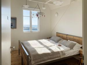 una camera da letto con un letto grande con una finestra di Melar Guesthouse a Kópasker