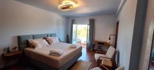 una camera da letto con un letto, una sedia e una finestra di Monte da Silveira a São Teotónio