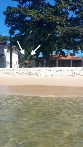 una vista di una spiaggia con un albero e una casa di Maré Zen Gamboa do Morro, 50m PRAIA a Morro de São Paulo