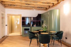 a dining room with a table and chairs and a kitchen at Palazzo Reggiani - Lorenzo De Medici in Verona +59 photos