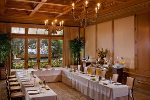 a banquet room with tables and chairs and a chandelier at The Resort at Pelican Hill in Crystal Cove