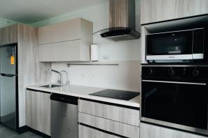 a kitchen with a sink and a microwave at Modern & Stylish 2BR Condo C11 at Playa Venao in Playa Venao