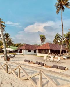 a beach with chairs and a building with palm trees at Beautiful Luxury Beachfront Hosue in Lorica
