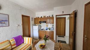 a kitchen with a table with a bowl of fruit on it at Apartments with parking space Pinezici, Krk - 5319 in Pinezici