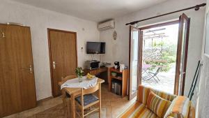 mały salon ze stołem i telewizorem w obiekcie Apartment Pinezici 5319b w mieście Pinezići