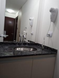 a bathroom counter with a sink and a mirror at Veneto Village Departamento in Villa Parque Siquiman