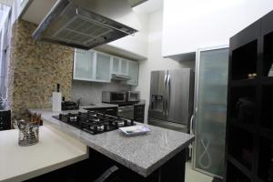 y cocina con fogones y nevera. en Boutique Apartment PBK, en Ciudad de México