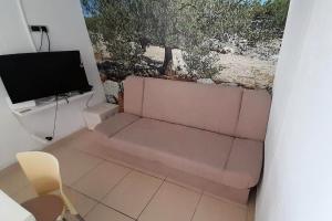 ein Wohnzimmer mit einem rosa Sofa und einem Fernseher in der Unterkunft Seaside holiday house Sevid, Trogir - 23061 in Sevid
