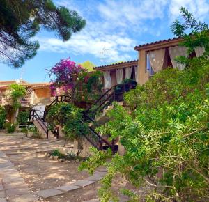 a house with a staircase with flowers on it at Alba Majore beach apartment in Rena Majore