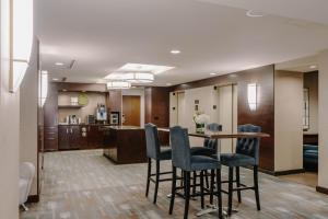 a dining room and kitchen with a table and chairs at Club Quarters Hotel Wacker at Michigan, Chicago in Chicago