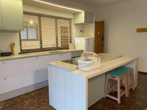 a kitchen with white cabinets and a counter with a sink at Apartamento tropical no centro de Pomerode in Pomerode