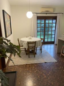 a dining room with a white table and chairs at Apartamento tropical no centro de Pomerode in Pomerode +12 photos
