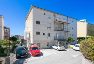 un edificio de apartamentos con coches aparcados en un aparcamiento en Apartments with a parking space Stobrec, Split - 23476, en Split 10 fotos más