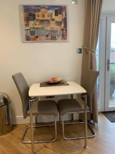 a table and chairs in a living room at Bayside at 9 The Dome Barton on Sea in Barton on Sea