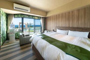 a bedroom with a large bed and a large window at Nagasaki Chapel Coconuts Hotel ＆Resort in Isahaya