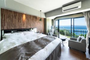a bedroom with a large bed and a large window at Nagasaki Chapel Coconuts Hotel ＆Resort in Isahaya