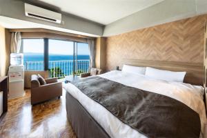 a bedroom with a large bed and a large window at Nagasaki Chapel Coconuts Hotel ＆Resort in Isahaya