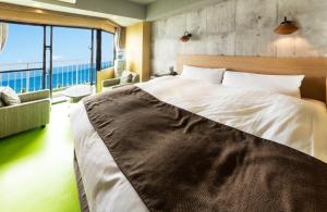 a bedroom with a large bed with a large window at Nagasaki Chapel Coconuts Hotel ＆Resort in Isahaya
