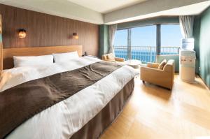 a bedroom with a large bed and a large window at Nagasaki Chapel Coconuts Hotel ＆Resort in Isahaya