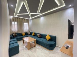a living room with a blue couch and a table at Alquds اقامة القدس in Fnidek