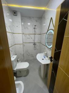a bathroom with a toilet and a sink and a mirror at Alquds اقامة القدس in Fnidek +16 photos